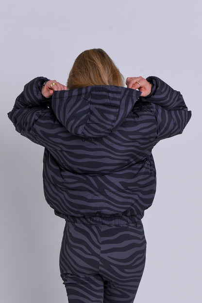 Person wearing a zebra-striped puffer suit against a white background